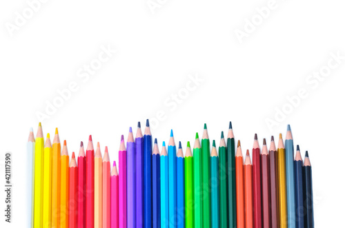 Composition with colored pencils on white background, top view