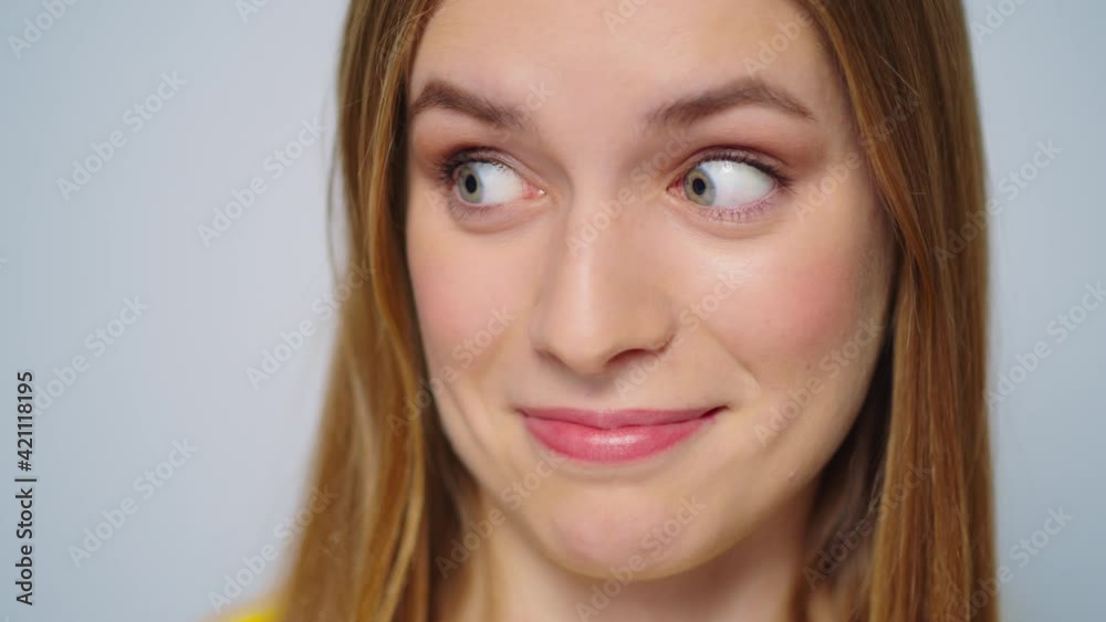 Closeup surprised woman smiling at camera on grey background. Funny girl face Closeup surprised woman smiling at camera on grey background. Funny girl face