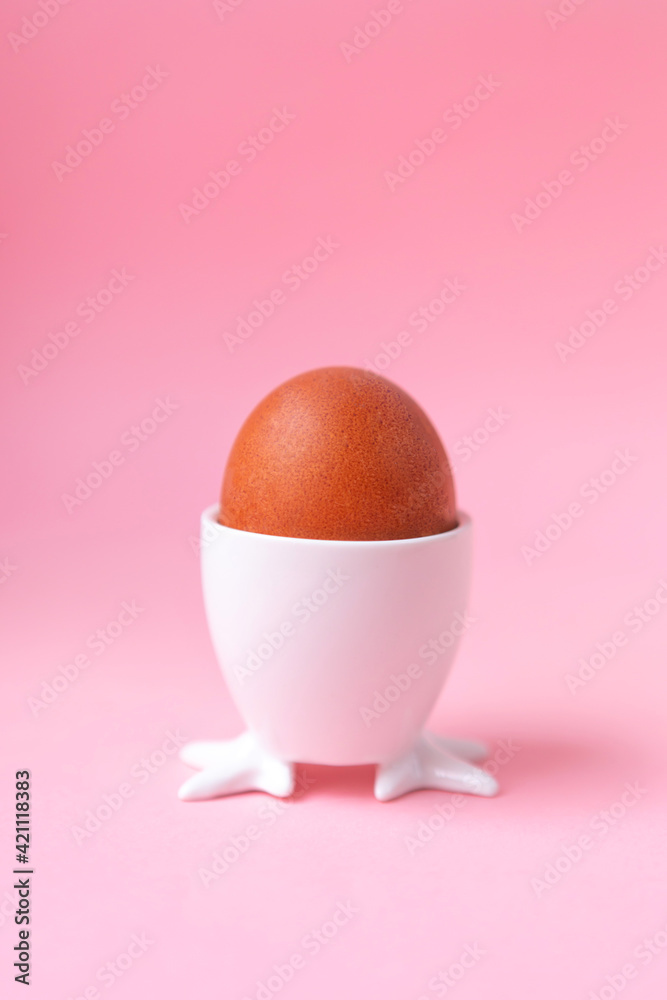 red egg in a stand, on a pink background, egg to Easter