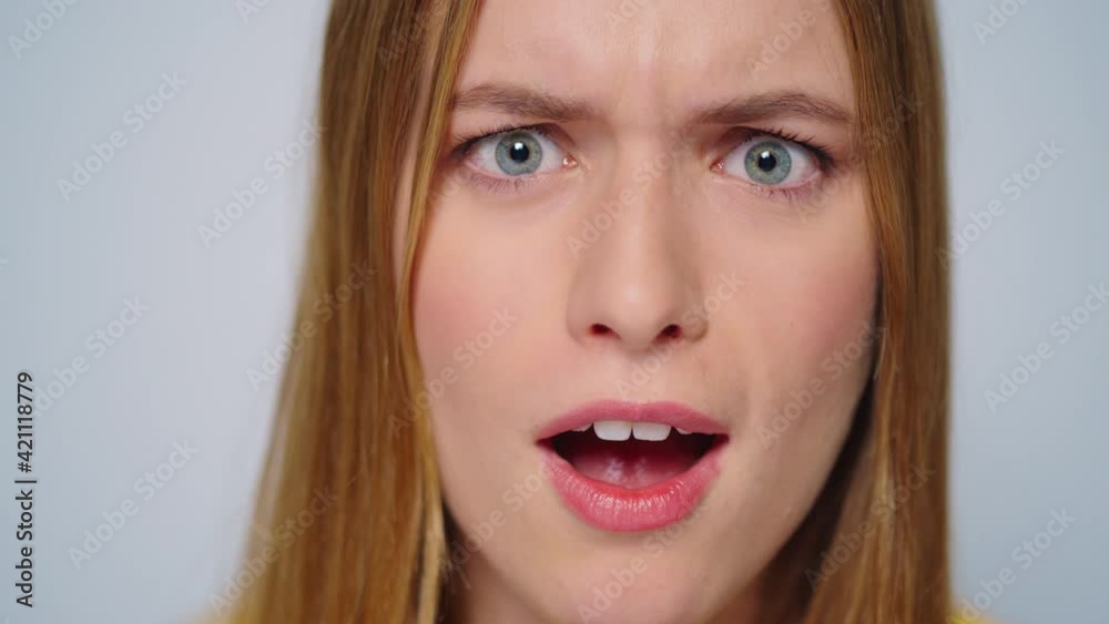Closeup angry woman shouting with aggressive emotion at camera in studio. Closeup angry woman shouting with aggressive emotion at camera in studio.