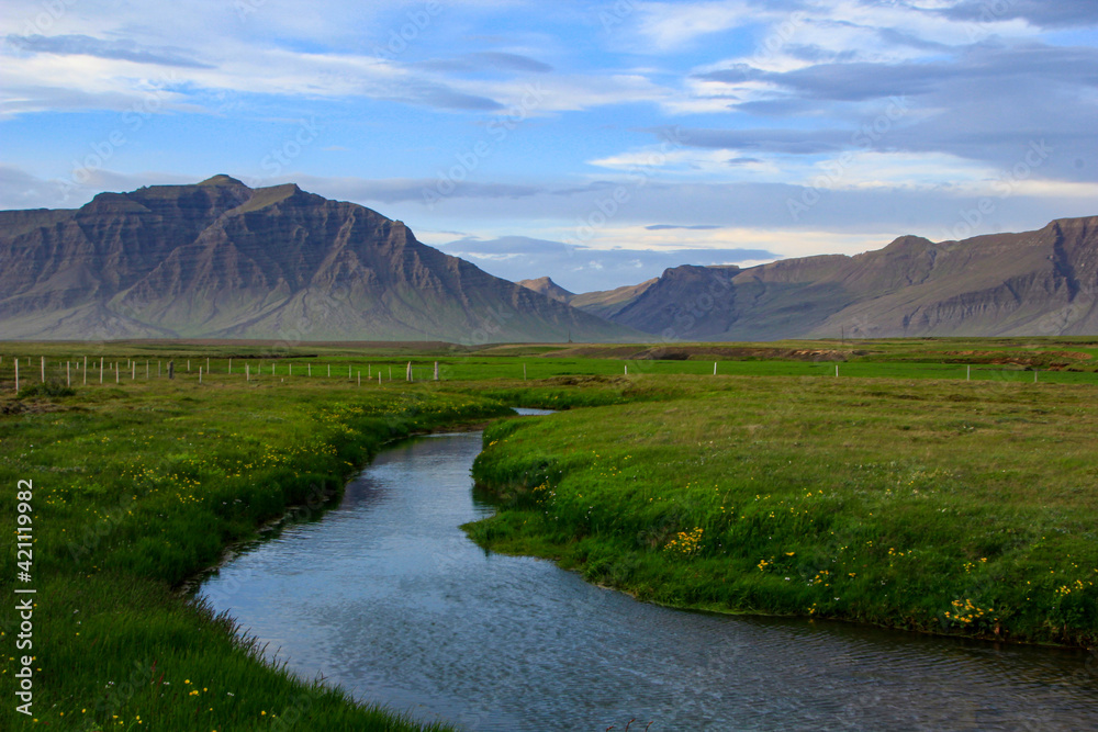 Fototapeta premium Stream and meadow with distant mountain range, Snaefellsnes peninsula, Iceland