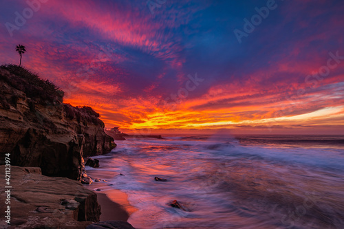 Dramatic fiery colorful sunset over crashing pacific ocean waves in La Jolla San Diego California 
