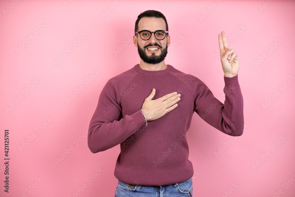 Handsome man wearing glasses and casual clothes over pink background smiling swearing with hand on chest and fingers up, making a loyalty promise oath Handsome man wearing glasses and casual clothes over pink background smiling swearing with hand on chest and fingers up, making a loyalty promise oath