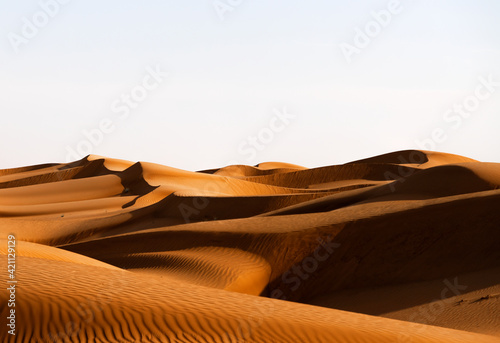 Sand desert at sunset and the shadow of the dunes