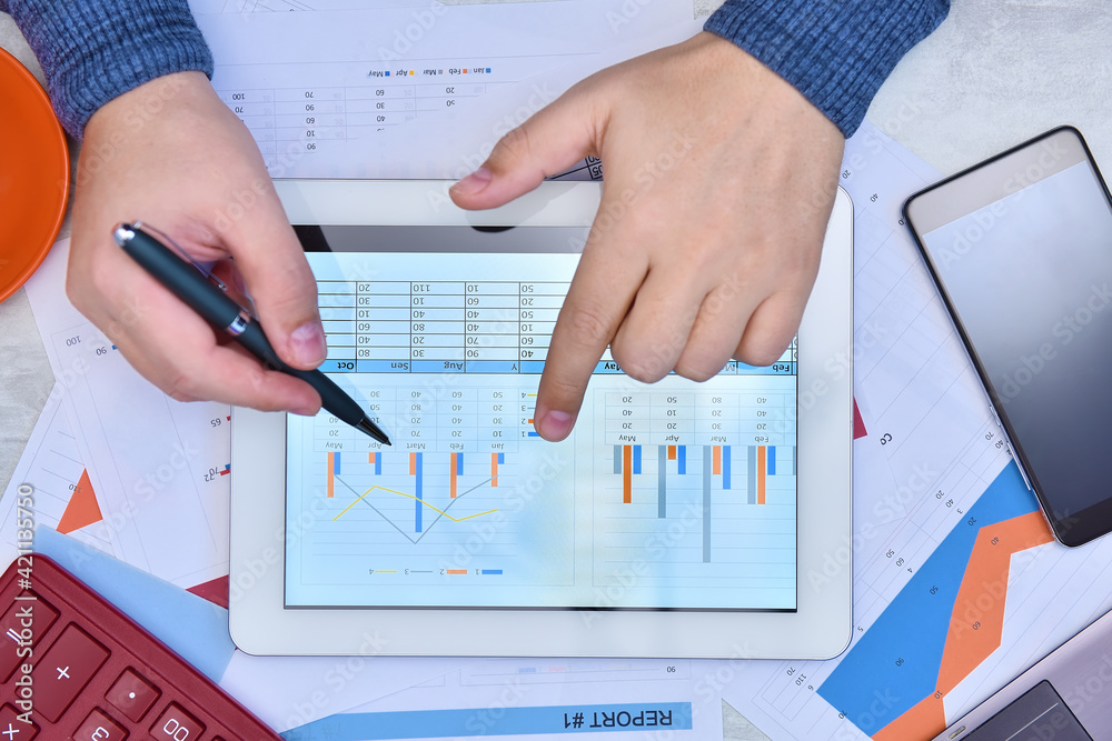 Hand using digital tablet and checking stock market data. Hand using digital tablet and checking stock market data.