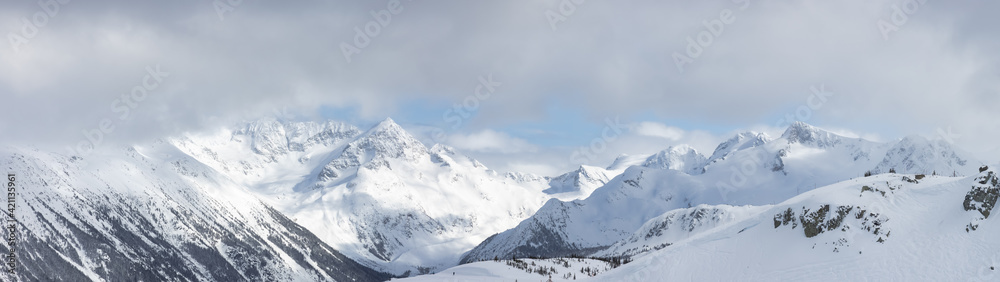 Whistler, British Columbia, Canada. Beautiful Panoramic View of the Canadian Snow Covered Mountain Landscape during a cloudy and vibrant winter day. Nature Background Panorama