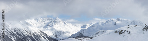 Whistler, British Columbia, Canada. Beautiful Panoramic View of the Canadian Snow Covered Mountain Landscape during a cloudy and vibrant winter day. Nature Background Panorama © edb3_16