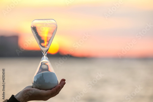 Female hand with stylish hourglass outdoors