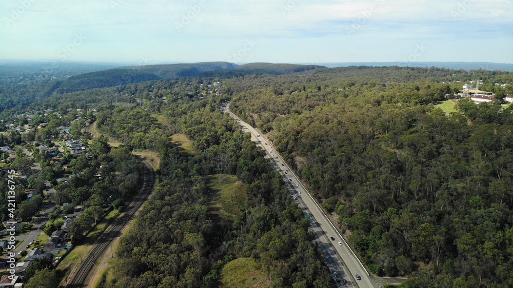 Drone image of the m4 motorway leading into the Blue Mountains from Western Sydney on a sunny day.