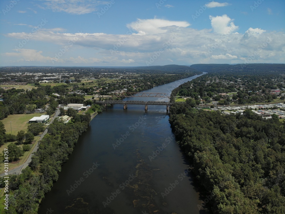 Railway bridge crossing the Nepean river at Penrith on a sunny spring day with blue sky and white clouds.