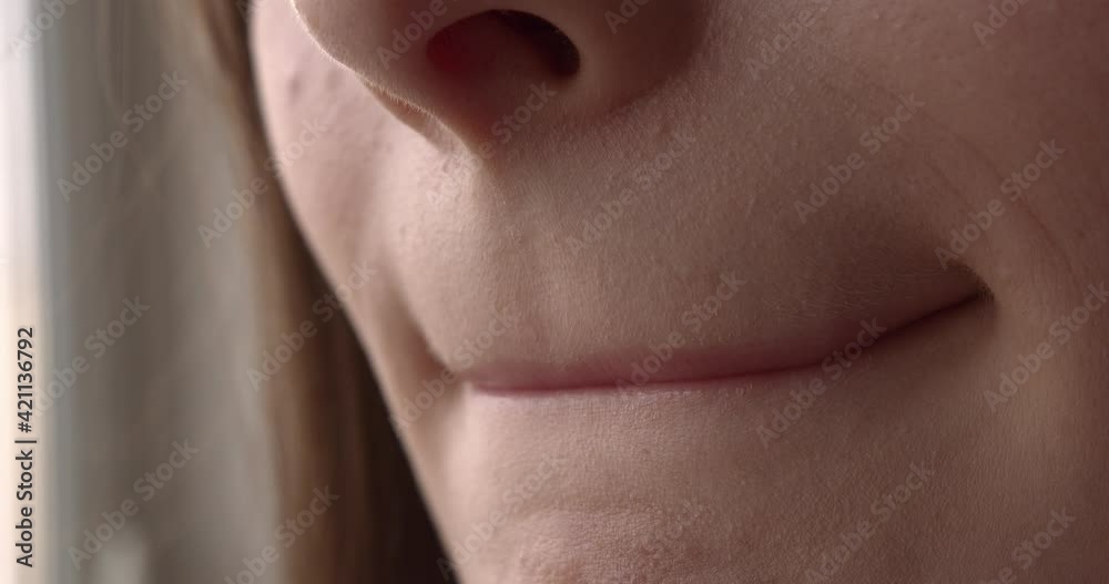 Young woman biting her lips. Close up of female mouth. Natural beauty and clear skin. 