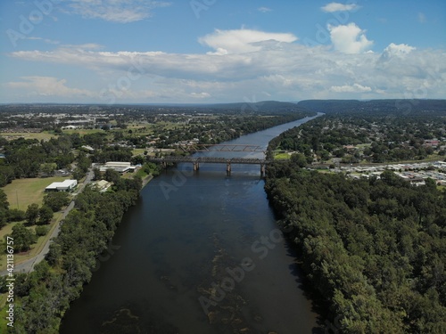 Railway bridge crossing the Nepean river at Penrith on a sunny spring day with blue sky and white clouds.