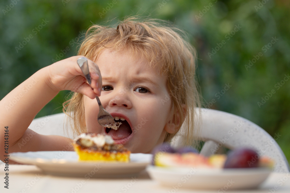 Baby eating cake. Child eat cupcake outdoors. Baby eating cake. Child eat cupcake outdoors.