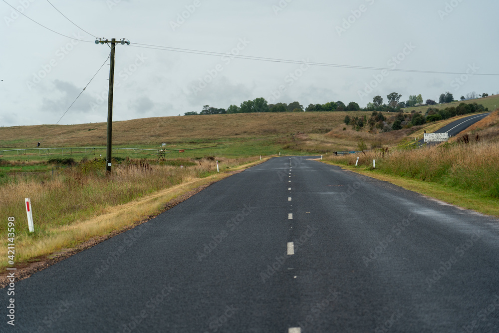empty road in the country leading into the horizon with rolling hills