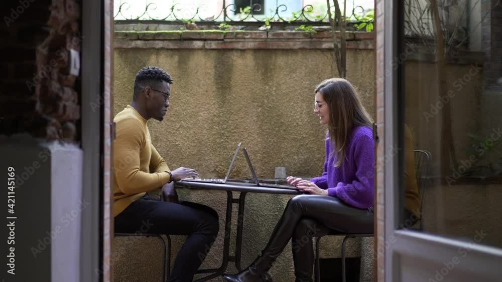 People working in front of computer laptop at home. African man and young white woman together People working in front of computer laptop at home. African man and young white woman together