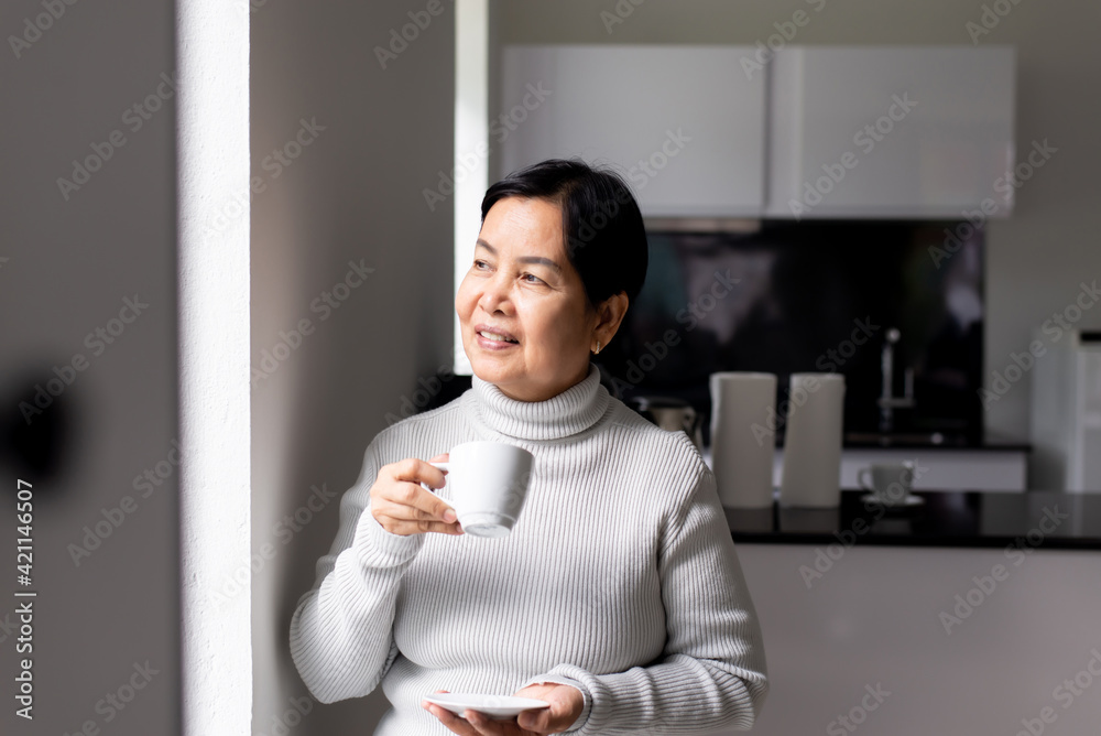 Elderly asian woman drinking coffee at home,Happy and smiling,Health care senior insurance concept