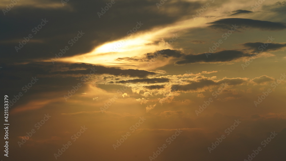 The beautiful sunset view with the round sun and the colorful clouds in the sky