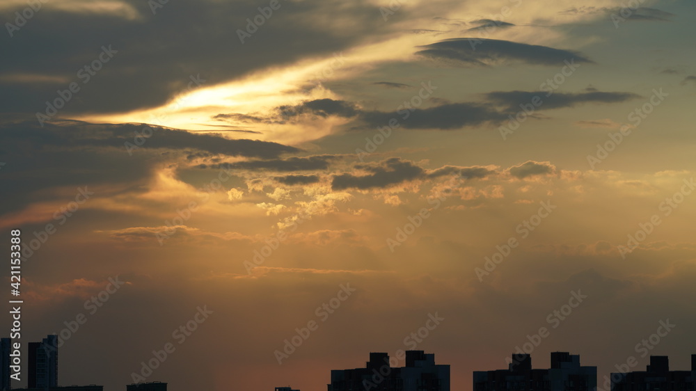 Fototapeta premium The beautiful sunset view with the round sun and the colorful clouds in the sky