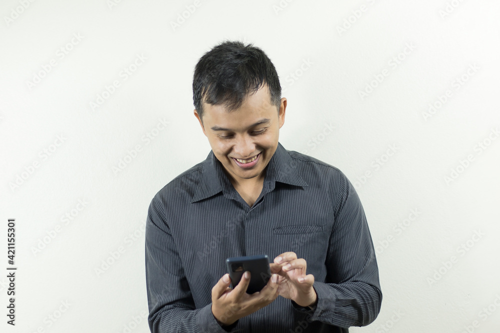 Portrait of a dark-skinned Asian man in business suit doing business on a smartphone.