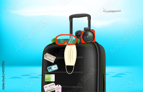 Summer travel concept with baggage, camera, protective mask. Summer 2021