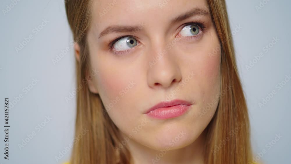 Closeup pensive woman choosing idea at camera on grey background. Thinking girl Closeup pensive woman choosing idea at camera on grey background. Thinking girl