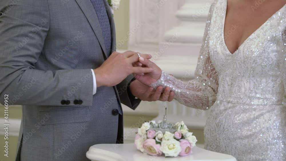 The bride puts a ring on the grooms finger at the wedding ceremony. Exchange of rings. High quality FullHD footage The bride puts a ring on the grooms finger at the wedding ceremony. Exchange of rings. High quality FullHD footage