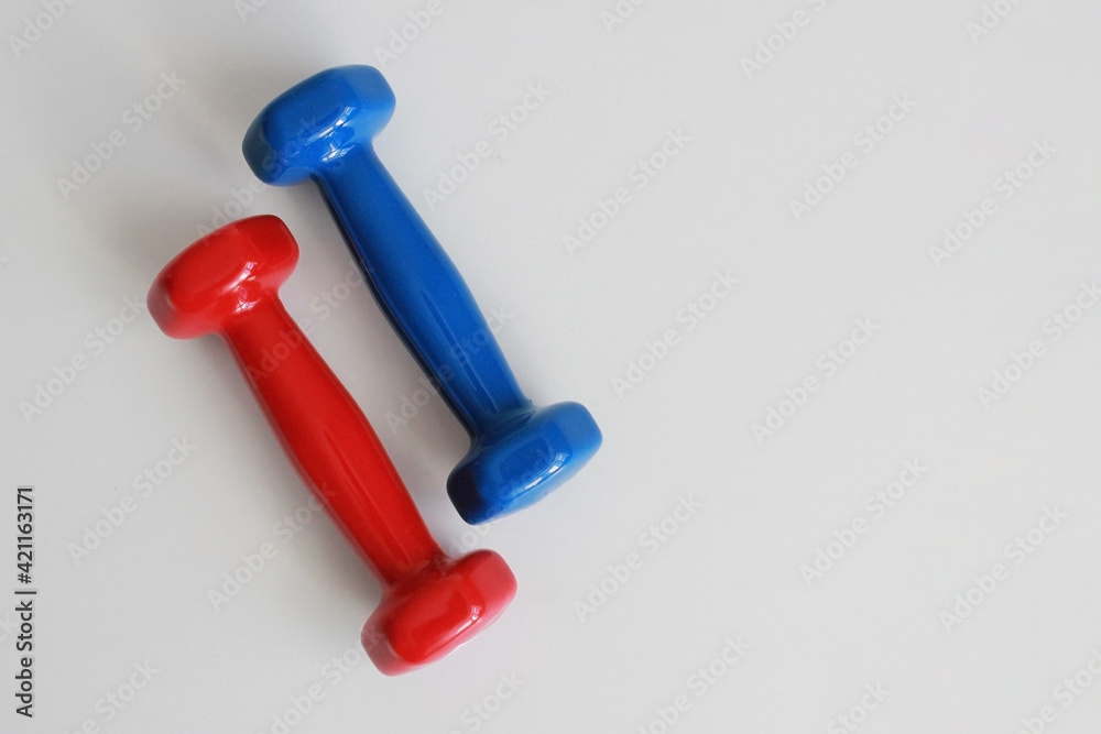 red and blue dumbbells on white table red and blue dumbbells on white table