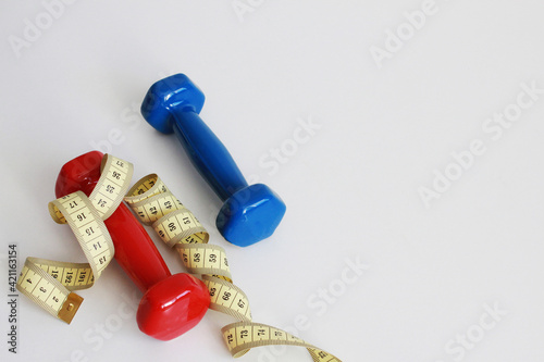 dumbbells and measuring tape, sports and weight loss