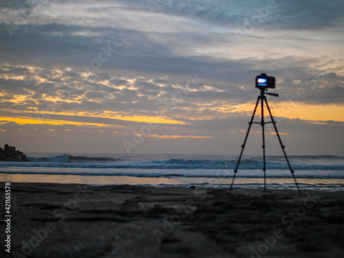 朝焼けの海で撮影を待つカメラマンの風景