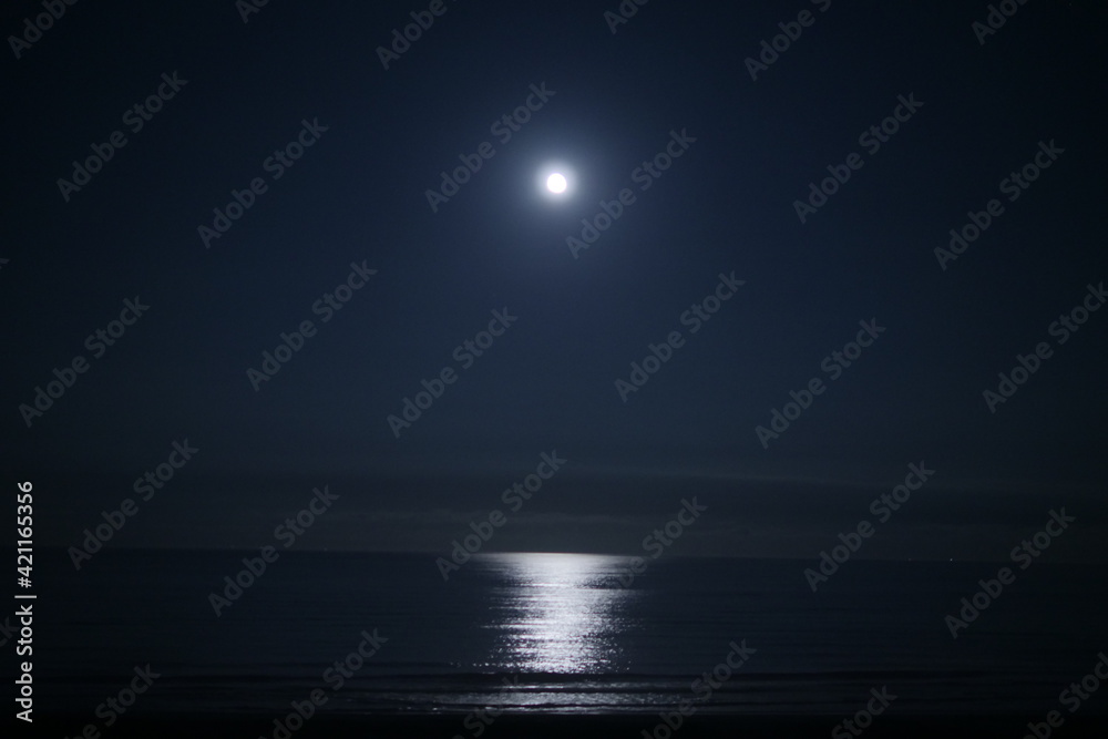 闇夜の海面を照らす満月