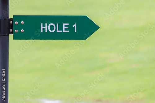 Obraz na plátně Signs for the tee off at the golf course, hole 1 with green background