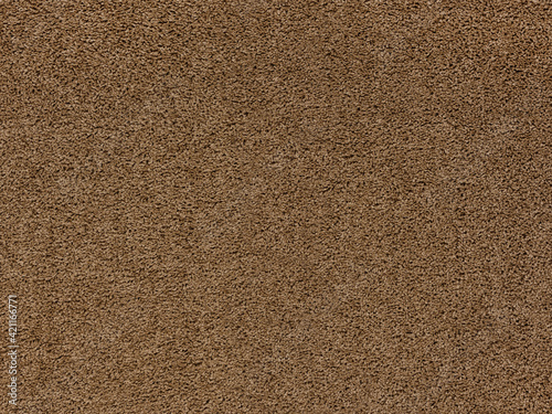 A closeup of a beige-colored soft textured carpet.