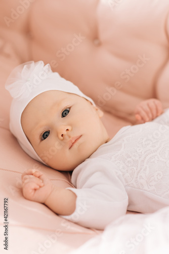 Portrait of a cute 6-month-old baby, a newborn girl lying in a baby crib