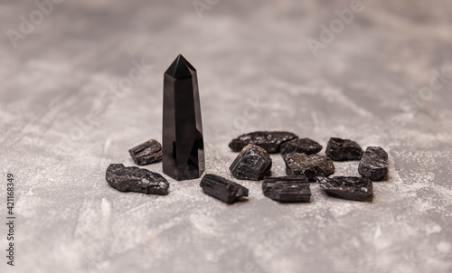 Black obsidian crystal wand. Natural rock specimen - raw crystal of black obsidian gemstone. Many pieces of crystal of natural stone black tourmaline. Shorl. Balancing the soul. photo
