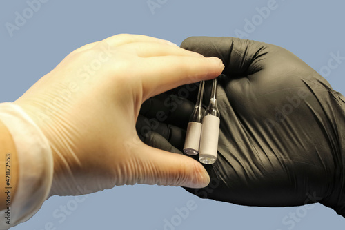 Sterile ampoules with vital medicine are in the hand, there is a place to insert the text.
