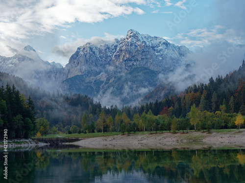 Lake Jasna's upper lake with mt. Prisojnik in the background, glooming in autumn weather and colours. Lake Jasna consists of two smaller artificial lakes in Kranjska Gora, Slovenia.