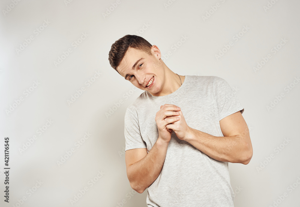 Cheerful handsome man in a white t-shirt smile studio light background Cheerful handsome man in a white t-shirt smile studio light background