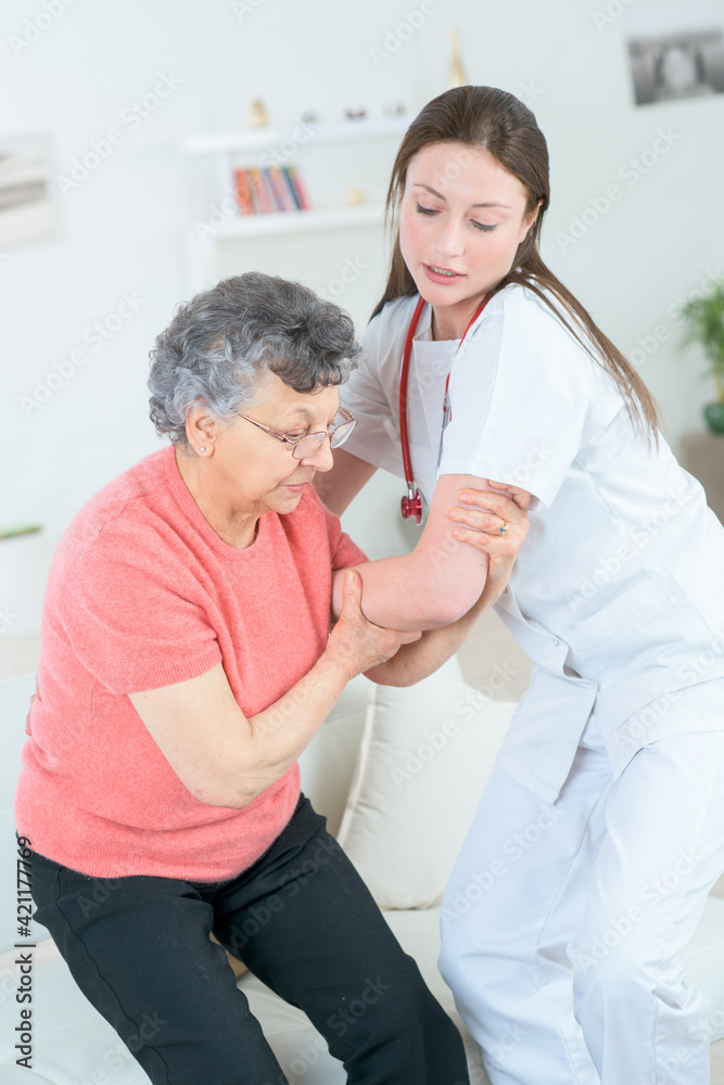 Obraz premium helping old lady to sit sofa