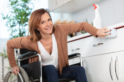 beautiful woman on a wheelchair doing cleaning