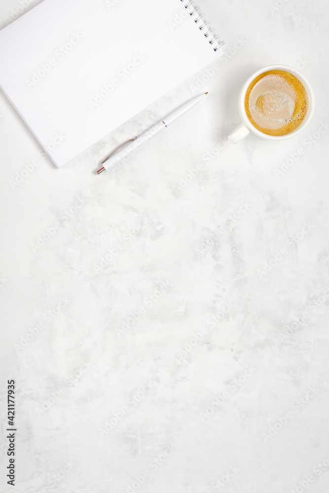 Cup of coffee, open notebook and pen on a light concrete background. Workplace top view Cup of coffee, open notebook and pen on a light concrete background. Workplace top view