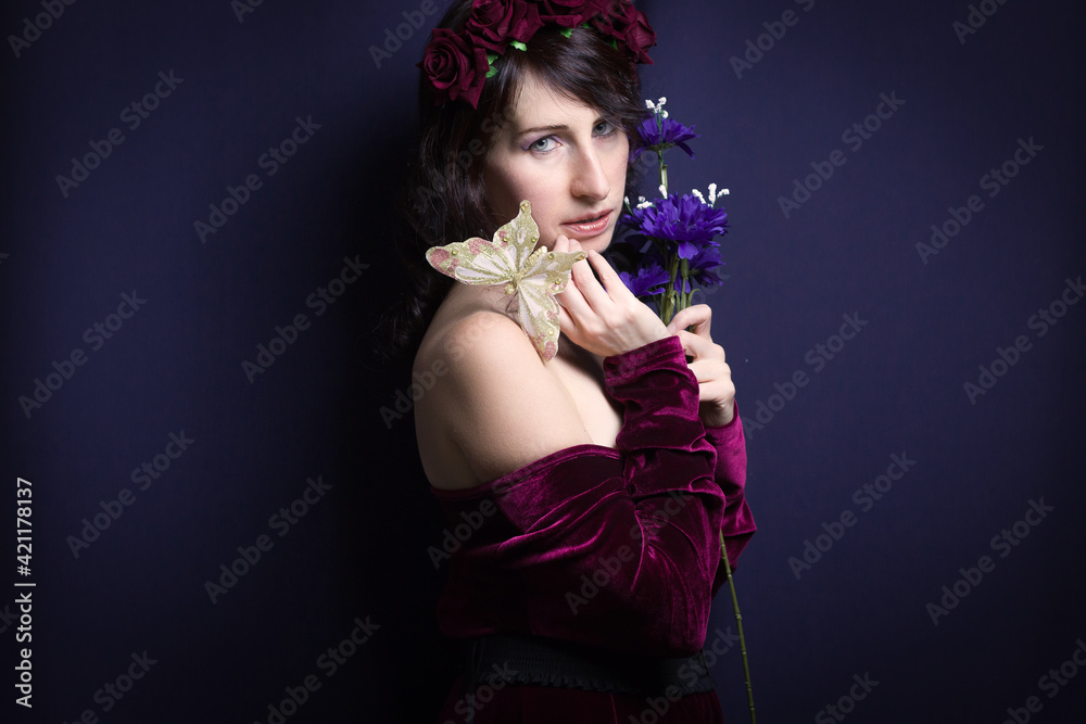 Studio shot of spring woman with butterfly and bouquet of blue flowers Studio shot of spring woman with butterfly and bouquet of blue flowers