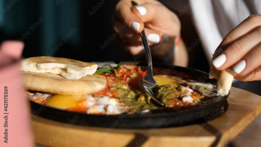 Eating Shakshuka Poached Eggs with Tomato and Bread Served in a Frying Pan. Israeli Arab Middle Eastern Cuisine. 4k Eating Shakshuka Poached Eggs with Tomato and Bread Served in a Frying Pan. Israeli Arab Middle Eastern Cuisine. 4k