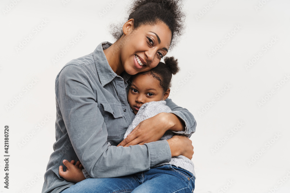 African mother and daughter smiling and hugging together African mother and daughter smiling and hugging together