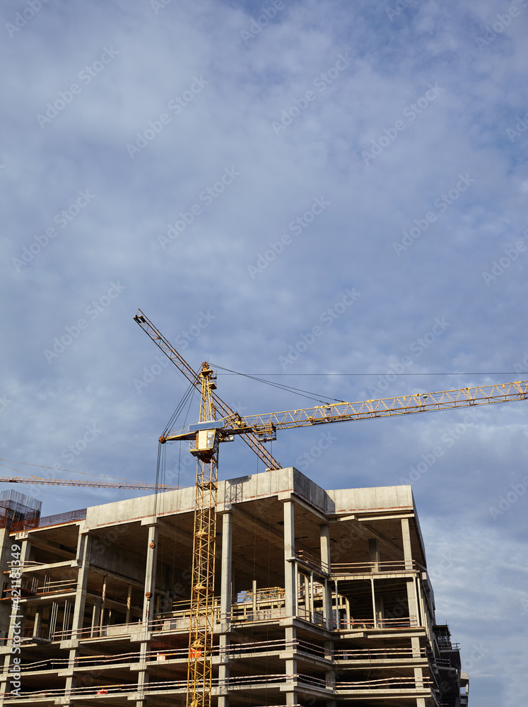 Tower crane building a house. Concrete building under construction Tower crane building a house. Concrete building under construction