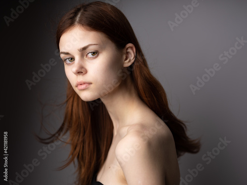 Side view of red-haired lady portrait on gray background beautiful face