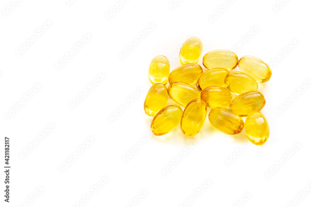 Shiny yellow fish oil capsules isolated on a white background. Vitamin E. Copy space for your text Shiny yellow fish oil capsules isolated on a white background. Vitamin E. Copy space for your text