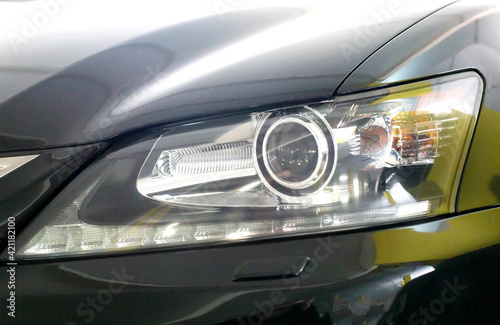 Headlight of a black car. Xenon with lens, modern, close-up
