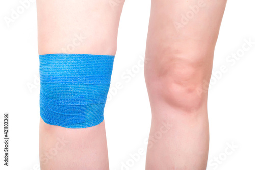 Blue elastic bandage on the knee joint to fix the sore kneecap, white background, isolate. Dislocation