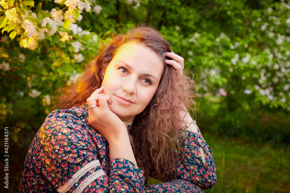 Girl in a long ethnic dress in a Park with blooming Apple trees with white flowers Girl in a long ethnic dress in a Park with blooming Apple trees with white flowers