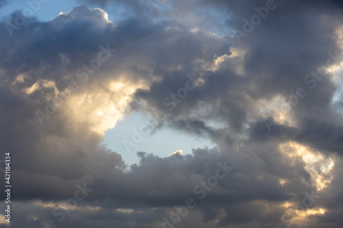 Detail of a white cloud in a bright blue sky. Dark rain clouds displace the blue sky. Storm is coming 